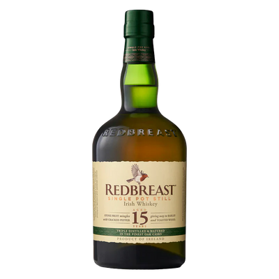 A bottle of Redbreast 15 Year Old Irish whiskey with a green glass body, cream label, and gold and red accents. The label displays a bird illustration and text highlighting this renowned Redbreast whiskey.