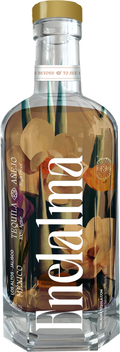 A clear glass bottle of Enelalma Tequila High Proof Añejo 750mL features a gold cap, bold white lettering, a floral and leaf design inside the bottle, and is aged in American white oak barrels for a refined finish.
