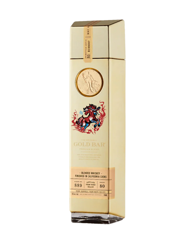 A tall, gold-colored bottle of Gold Bar Whiskey Year of the Horse 2026 Limited Edition features a raised gold coin, a decorative horse illustration, and a label noting it is American blended whiskey finished in California casks.